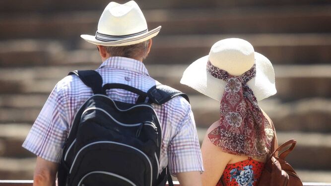 Dos turistas con sombrero frente al Teatro Romano.