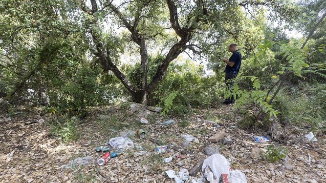 Un hombre toma imágenes del monte en Benahavís donde se ha encontrado una maleta con restos óseos de una mujer.