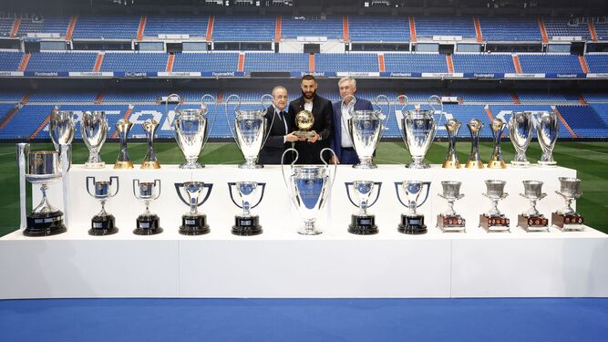 Florentino Pérez y Ancelotti posan con Benzema junto a todos sus trofeos.
