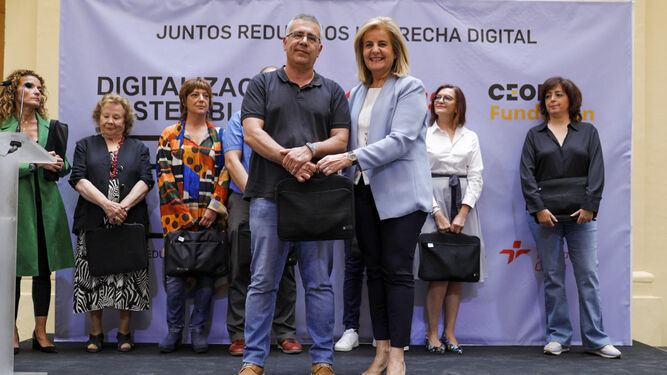 Fátima Báñez entrega uno de los ordenadores a los colectivos participantes.