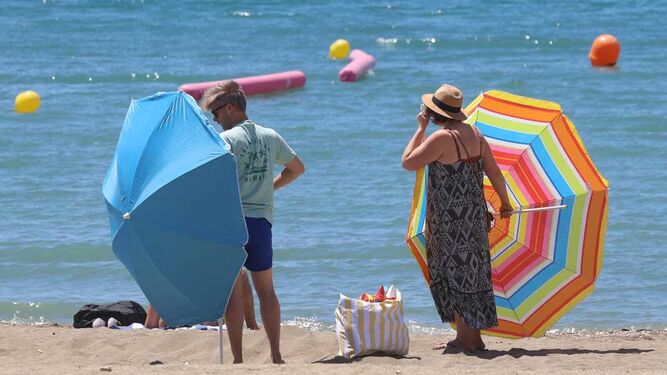 Bañistas colocando las sombrillas en la playa en Málaga, este miércoles.