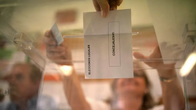 Una votante deposita su papeleta en una urna.