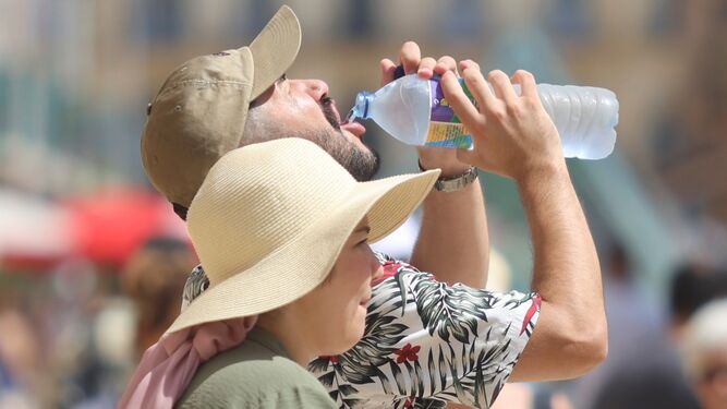 Un turista se refresca con una botella de agua en una calle de Málaga
