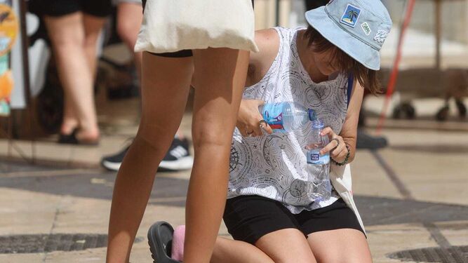 Una mujer se refresca con una botella de agua en Málaga ante la ola de calor