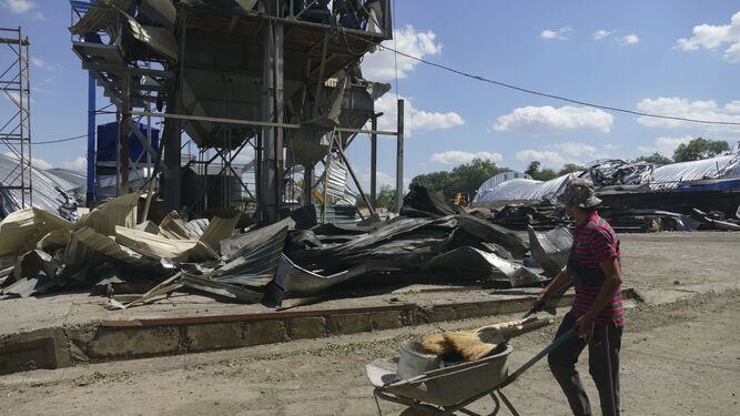 Un hombre trabaja en una dañada terminal de grano de una empresa agrícola de la región de Odesa.