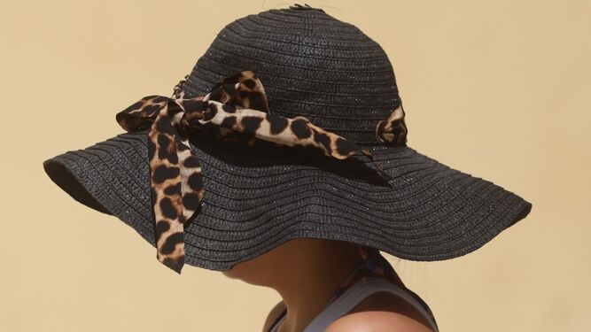 Una mujer con sombrero para protegerse del sol en Málaga.