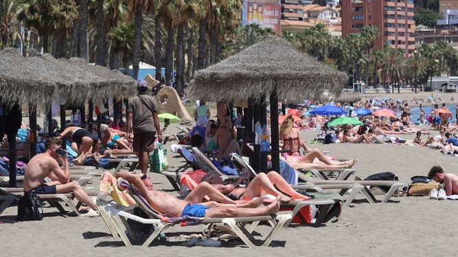 Personas tomando el sol en una playa de Málaga.