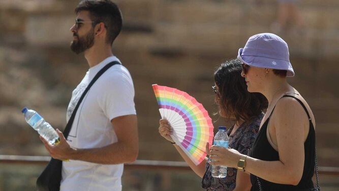 Varias personas pasean por el Centro Histórico de Málaga precavidas contra el calor.