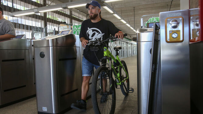 Un hombre empuja su bicicleta dentro de una estación de metro.