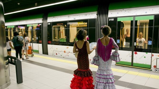 Dos mujeres de flamenca en una estación de metro de Málaga.