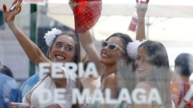 Tres jóvenes bailan durante la última jornada de la pasada Feria de Málaga.