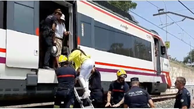 El cuerpo de bomberos y agentes de la Policía ayudan a desalojar el tren averiado en La Colina.