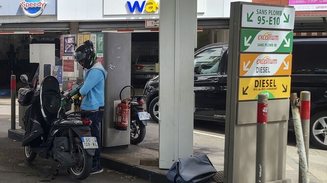 Una persona reposta su motocicleta en una gasolinera
