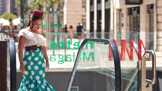 Una mujer vestida de flamenca saliendo del Metro en el centro.
