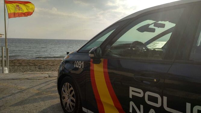 Un vehículo de la Policía Nacional frente a una playa.