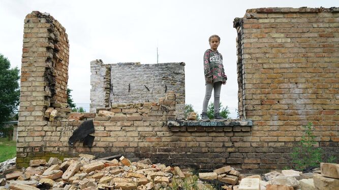 Una niña camina sobre los escombros de una escuela destruida en Horenka.