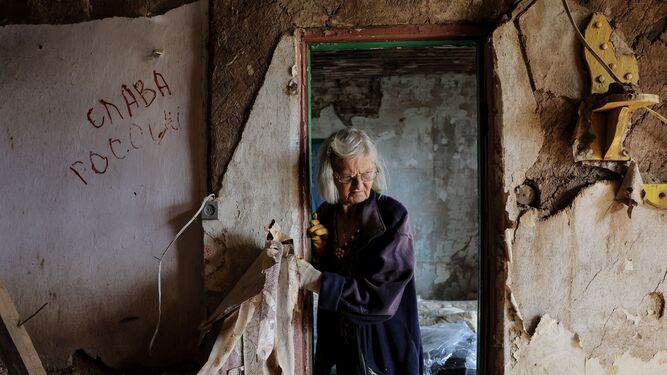 Una ucraniana repara su vivienda, ocupada por las tropas rusas y luego destruida por los bombardeos en la región de Jarkov.