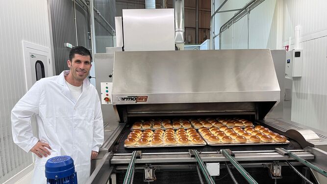 Carlos Pérez junto a la producción de pan de hamburguesa en la fábrica Juanito Baker