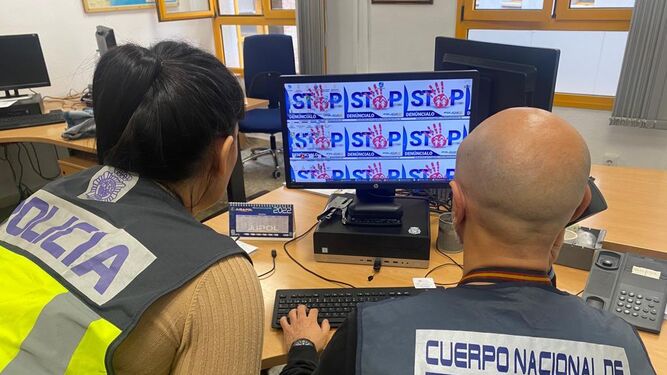 Agentes de Policía Nacional frente a un ordenador.