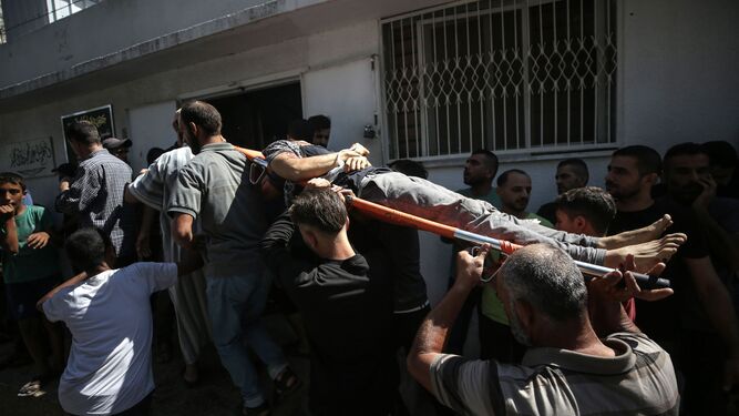 Un grupo de palestinos traslada a un herido por los ataques israelíes.