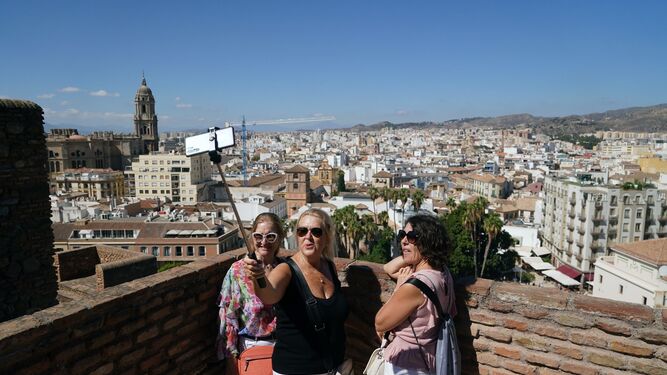 Tres turistas en Málaga realizando una fotografía