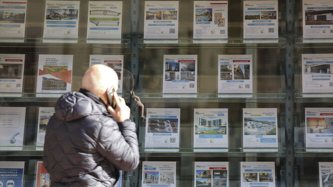 Una persona consultando los precios de una agencia inmobiliaria en Málaga