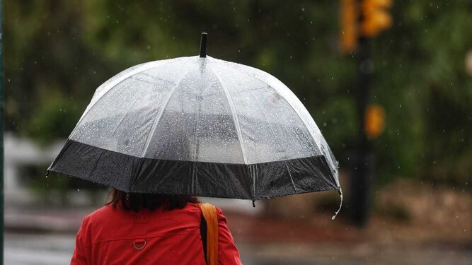 Una mujer protegiéndose de la lluvia con un paraguas