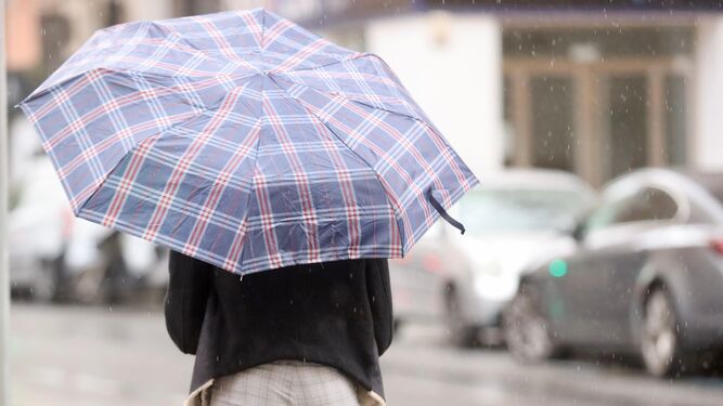 Una mujer se protege de la lluvia este domingo en Málaga.