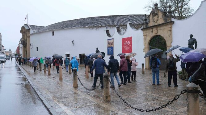 Un grupo de personas se protege de la lluvia junto a la plaza de toros de Ronda este lunes.