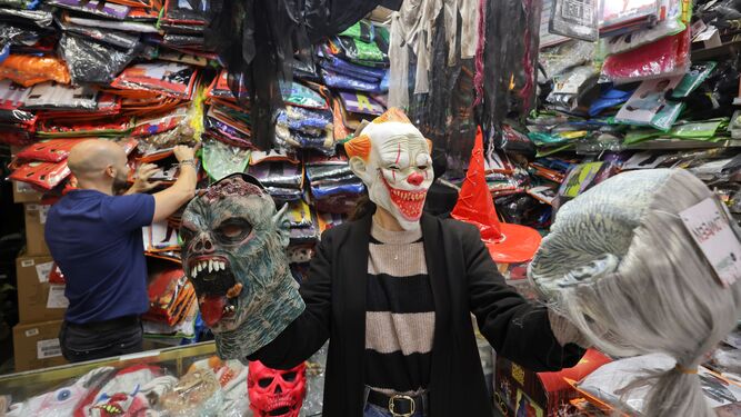 Una cliente probándose máscaras de Halloween en una tienda.