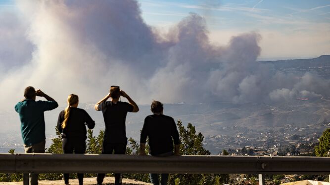 Un grupo de personas graba las llamas del incendio forestal en Mijas