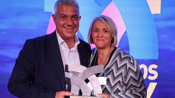 Toni de la Prieta y Nuria Iglesias posan posando con el galardón otorgado a Accenture.