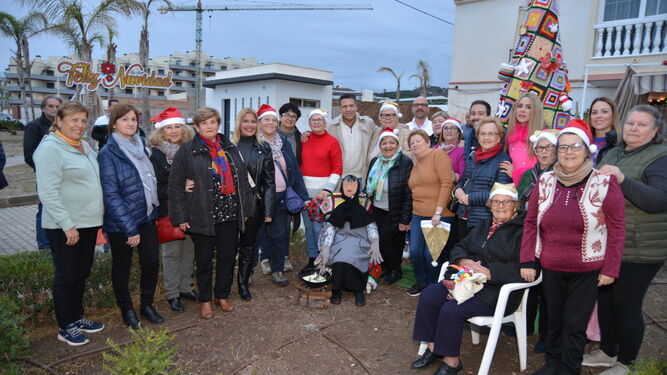 La Asociación de Mujeres La Carraca y autoridades municipales junto al árbol de Navidad de croché