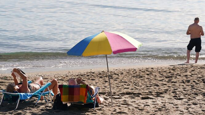 Varias personas disfrutan de un día de playa en pleno diciembre en la Malagueta.