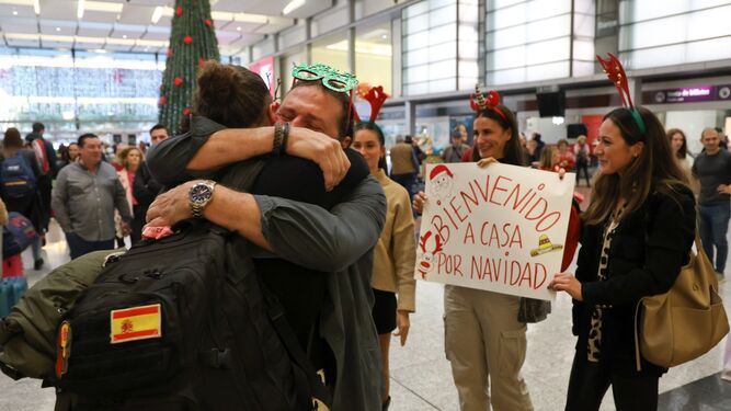 El padre de Emilio, emocionado, abraza a su hijo en presencia de su familia en la estación María Zambrano.