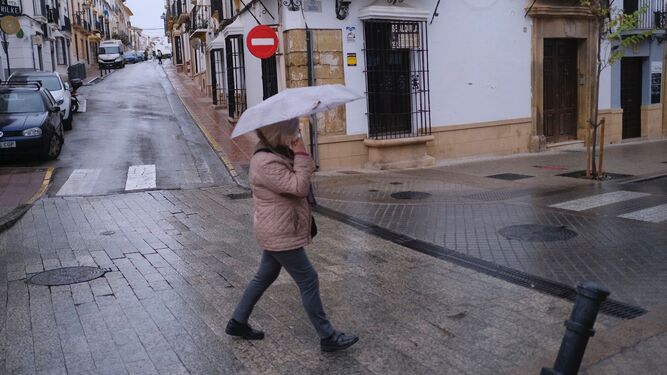 Una mujer protegiéndose de la lluvia en Ronda.