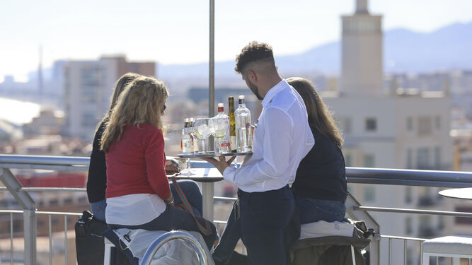 Un camarero atiende a una mesa en la terraza del AC Hotel Málaga Palacio