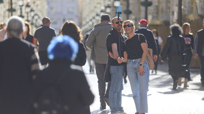 Una pareja haciéndose un selfie en calle Larios.