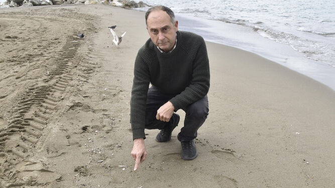 El biólogo y profesor del Instituto Universitario de Biotecnología y Desarrollo Azul (IBYDA) de la Universidad de Málaga (UMA) Juan Jesús Martín, posa en una playa de Málaga junto a pequeños residuos plásticos en la orilla.