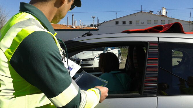 Un guardia civil examina la documentación de un vehículo.