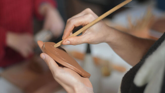 Usuaria del taller de cerámica dando forma a su creación.