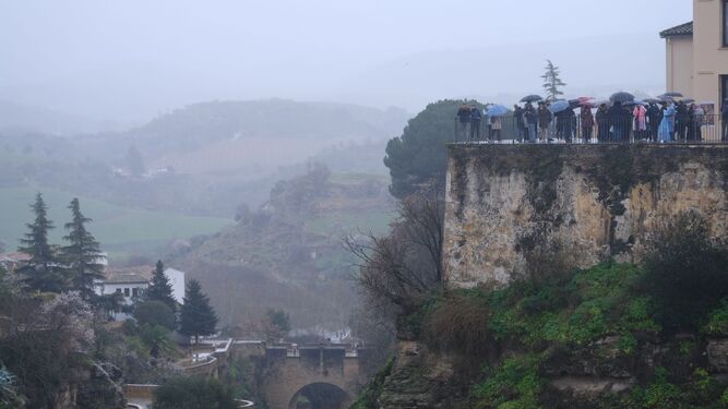 Turistas bajo la lluvia en Ronda, este viernes.