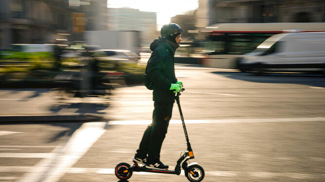 Un hombre circulando con un patinete  eléctrico.