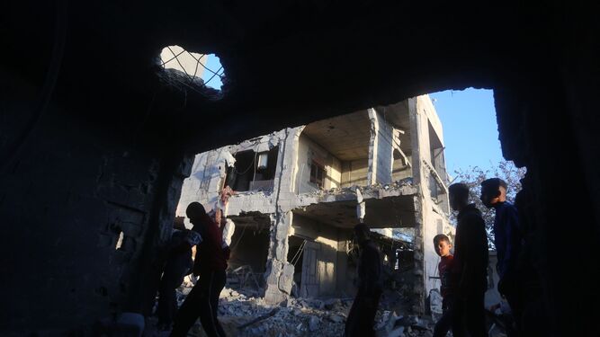 Varios palestinos comprueban los daños en una vivienda tras un bombardeo israelí en Rafah.