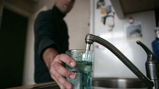 Un ciudadano llena un vaso de agua en su casa.