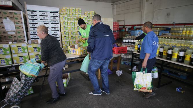 Voluntarios atienden a las personas que vienen a buscar comida en el almacén del Banco de Alimentos de Lugo.