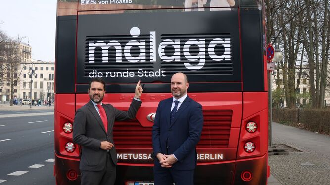 El concejal delegado de Turismo, Jacobo Florido, y el director general de Turismo, Jonathan Gómez, junto a un autobús turístico en Alemania.