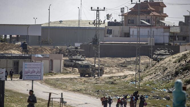 Tanques israelíes patrullan mientras grupos de palestinos abandonan sus hogares en Jan Yunis.