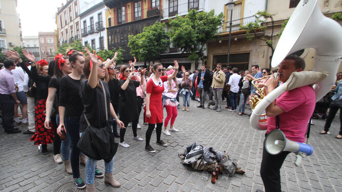 Un grupo de amigas bailan al son de la música en un plaza céntrica de Sevilla.