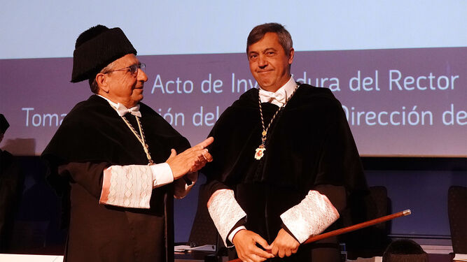 Teo López (derecha) recibe de su predecesor, José Ángel Narváez, la vara de mando de la UMA en su toma de posesión como rector.